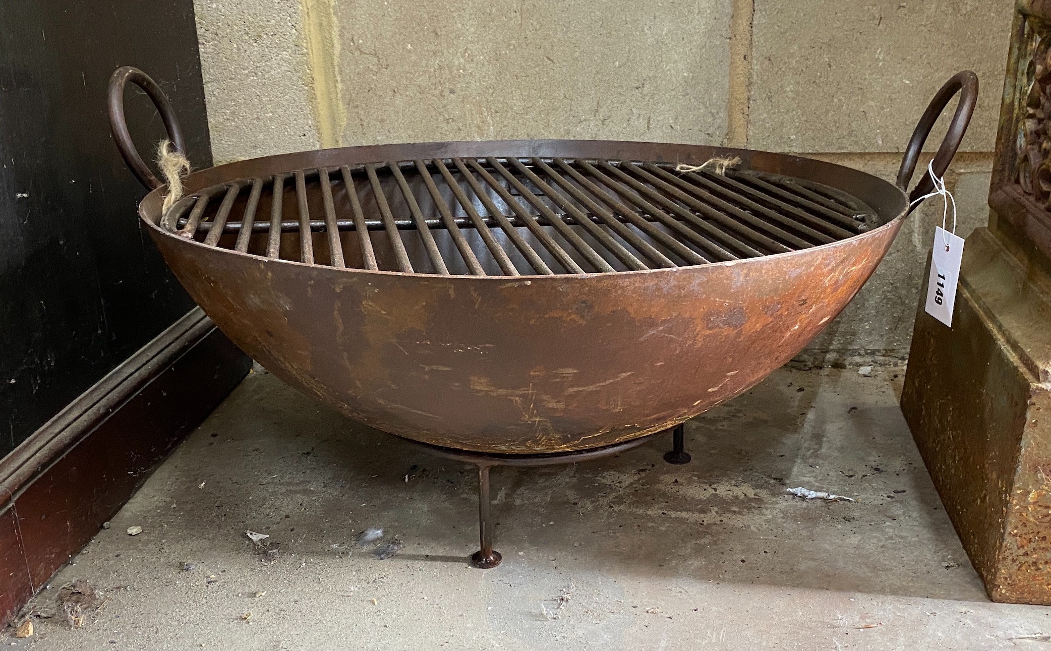 A circular wrought iron fire pit on low stand, diameter 62cm, height 37cm